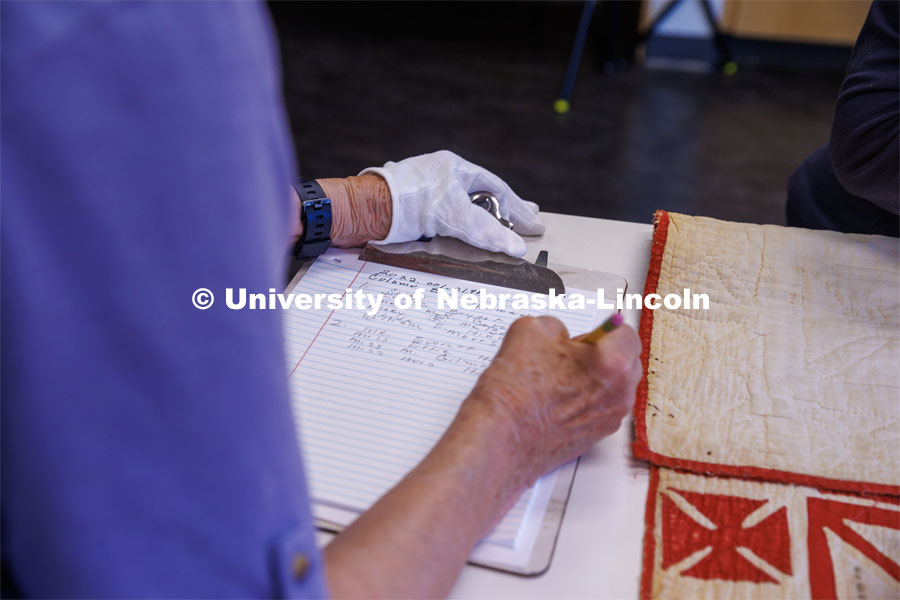 Volunteer Susan Macy (left) writes down the names off the quilt according to the column where they were located. International Quilt Study Center and Museum Genealogical Task Force. August 29, 2024. Photo by Kristen Labadie / University Communication.