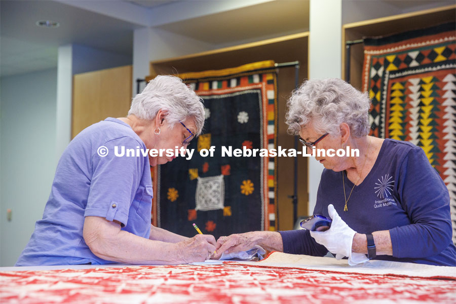 Volunteers Carolyn Kitterer (right) reads the names off the quilt while Susan Macy writes them down. International Quilt Study Center and Museum Genealogical Task Force. August 29, 2024. Photo by Kristen Labadie / University Communication.