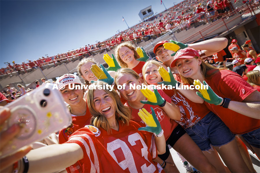 Jada Scribner, left, takes a selfie with Carrie Wehrman and friends as they show off their "corn hands" at the Nebraska football vs UTEP game. August 31, 2024. Photo by Craig Chandler / University Communication and Marketing.