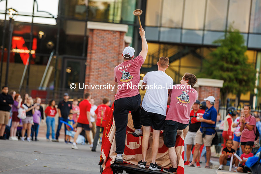 The Theta Chi Fraternity members wave a toilet plunger as the ride on their float at the 2024 Homecoming Parade. October 4, 2024. Photo by Kristen Labadie / University Communication.