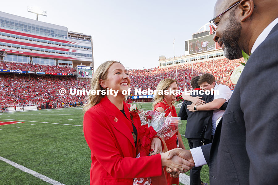 Homecoming royalty Emmerson Putnam, biological sciences major of Bellevue, Nebraska is congratulated by Chancellor Rodney D. Bennett. Nebraska vs Rutgers football game. Homecoming game. October 5, 2024. Photo by Craig Chandler / University Communication and Marketing.