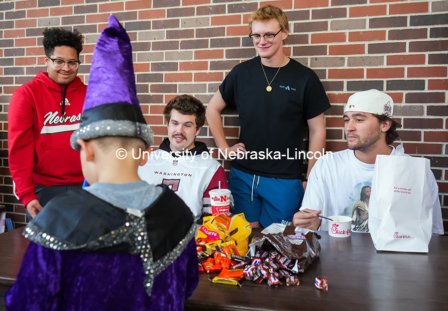 Tyson Barnard, Gavin Fee, Jeremiah Booth, Reid Scheming, and Aidan Herman from the Fraternity Acacia, hand out candy to little kids. The University hosted a public Trick-or-Treat event at the chapter houses on Greek row. October 29, 2024. Photo by Vienna Oldenhof for University Communication and Marketing.