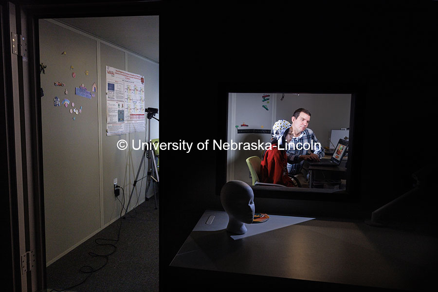 Kevin Pitt, Assistant Professor Special Education and Communication Disorders, demonstrates an electrode cap in the AAC Translation Lab with Aliyah Muniz, senior in communication science disorders. The subject views an image to see how the brain reacts when one object is highlighted. November 1, 2024. Photo by Craig Chandler / University Communication.
