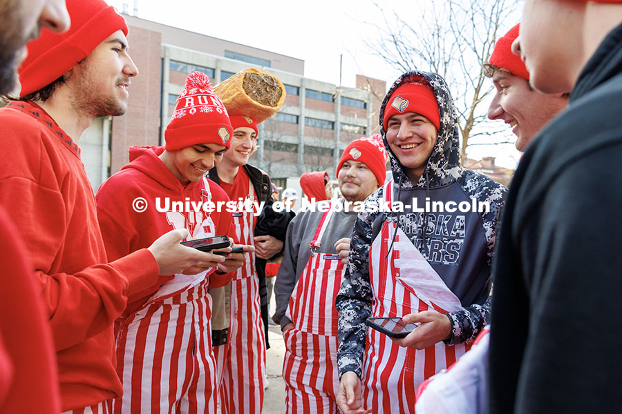 Smith Hall residents wearing red and white striped oversalls wait at the front of the line to enter Memorial Stadium. Nebraska vs. Wisconsin football game. November 23, 2024. Photo by Jordan Opp / University Communication and Marketing.