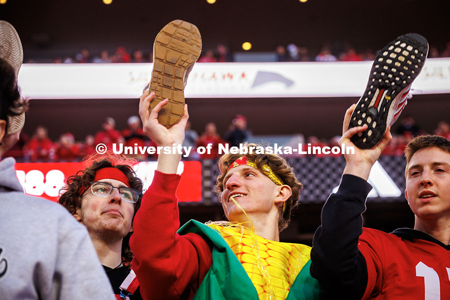 Students hold their shoes up at kick-off at the Huskers vs. Wisconsin football game. November 23, 2024. Photo by Kristen Labadie / University Communication.