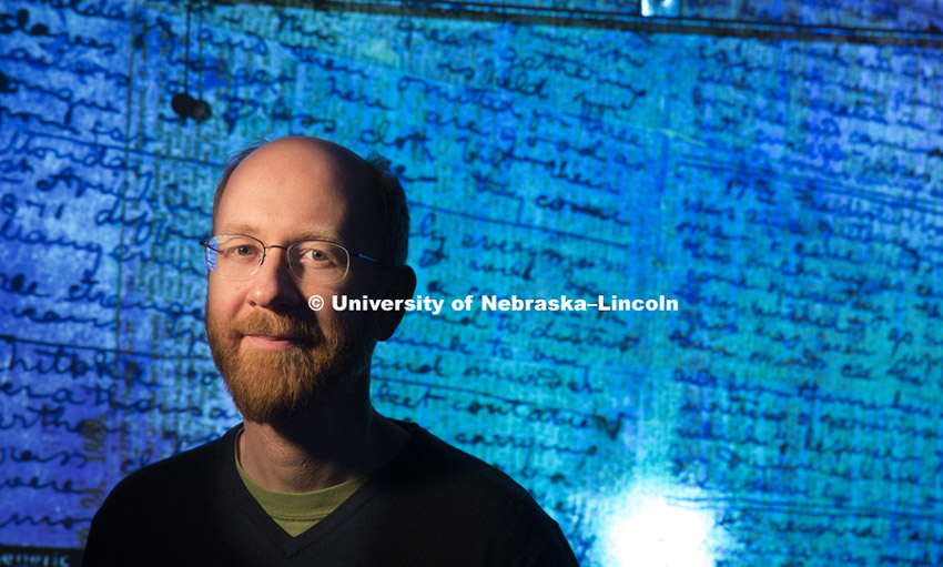 Adrian S. Wisnicki, assistant professor of English, stands in front of a projected image of Dr. Davi