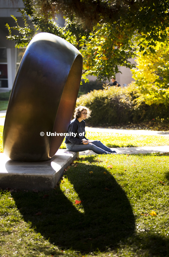 Miranda Russell sits in the shade of Fragment X-O in the Sheldon Memorial Sculpture gardens as she s