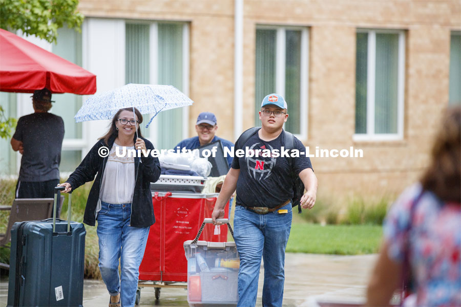 Tristan Smith carries his belongings as he moves in with the help of mom, Tina, and dad, Doug.  They