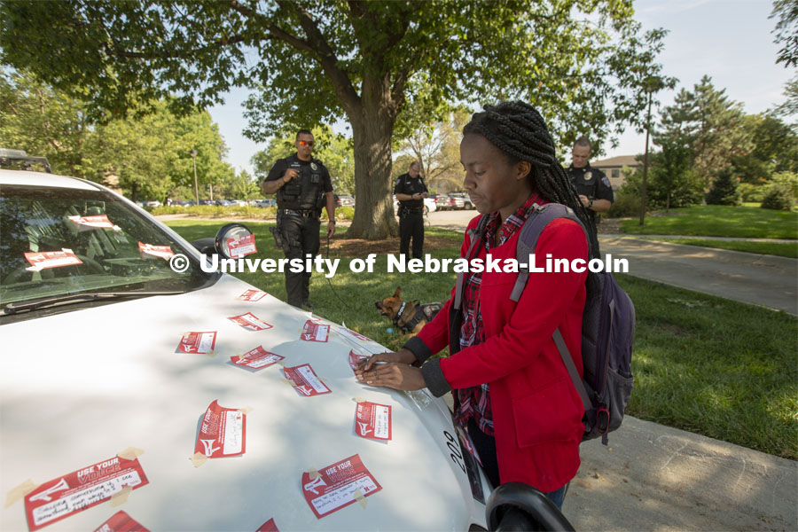 Elizabeth Uwase, a junior integrated science major from Rwanda, affixes her "Use Your Voice" pledge 