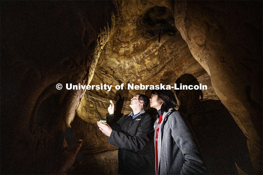 Professor Ricky Wood and PhD student Yijun Liao look over carvings in a side passage that connects t