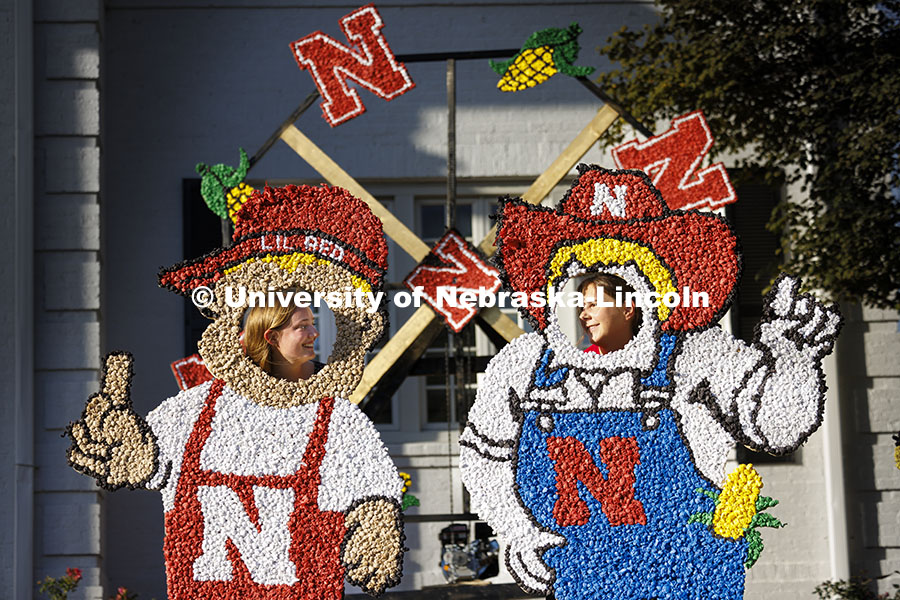 Sydney Honaker and Abby Veiman try out the Lil Red and Herbie lawn decorations in front of the Phi K