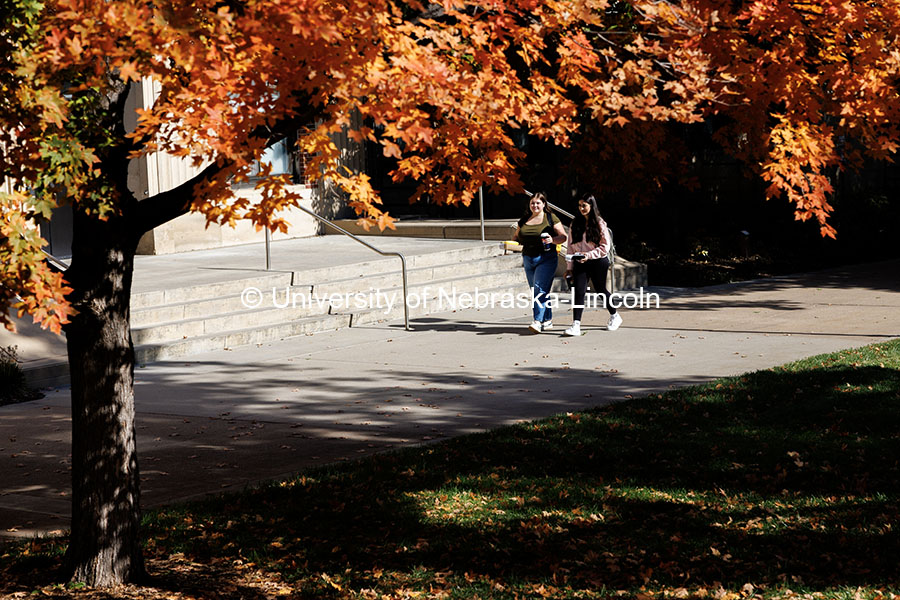 Freshman Lauren Addink, left, and Anna Chavez Ruiz enjoy the nice fall weather as they walk past And