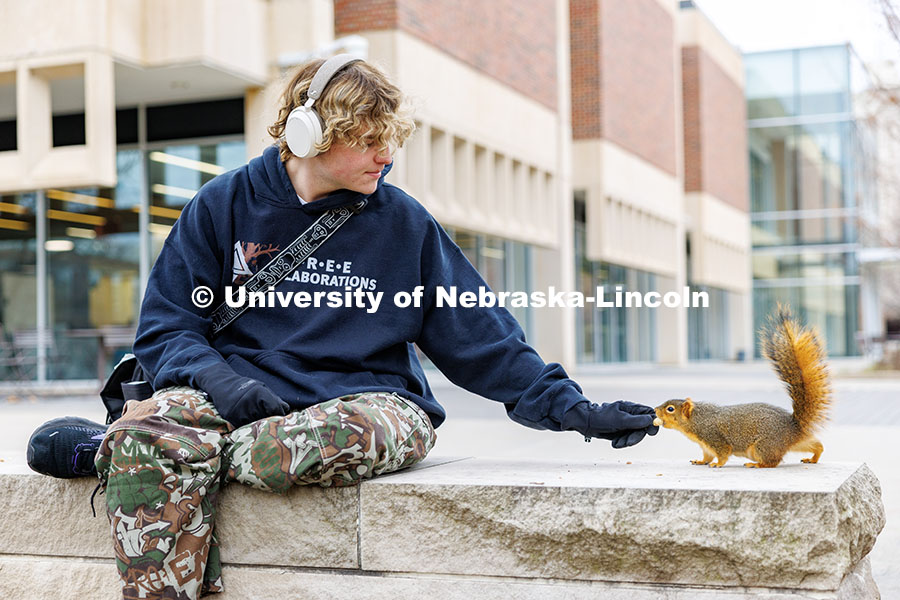 Dalton Dailey, junior, feeds squirrels outside of Love Library. December 17, 2024. 