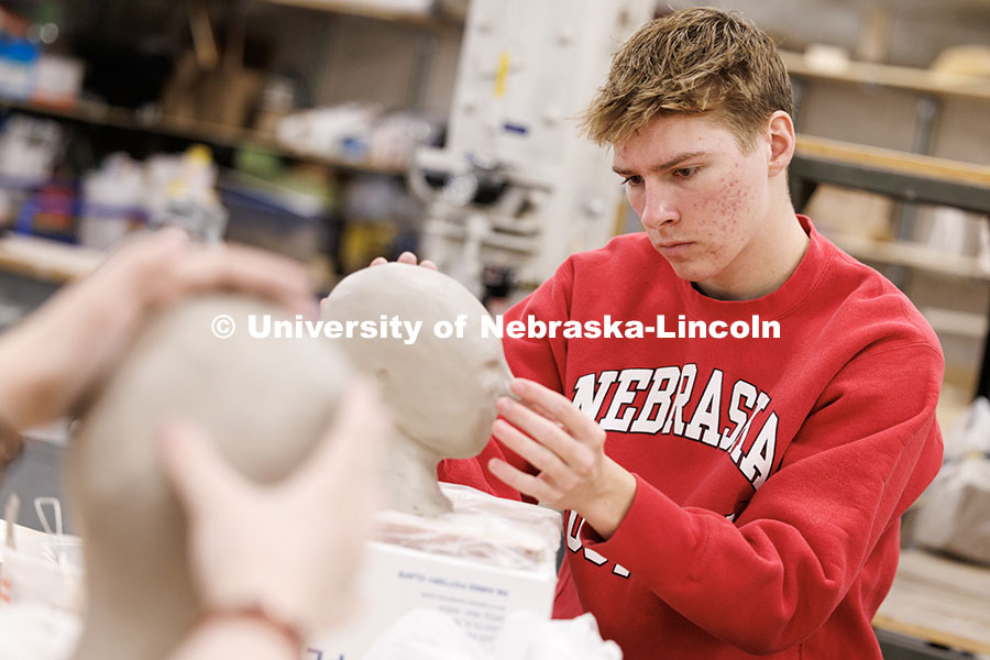 Ted Lueders, junior Microbiology major, models his clay head during his Beginning Sculpture class in