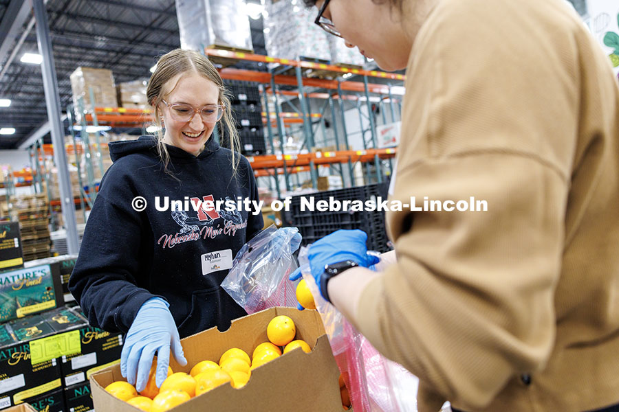 Meghan McDonald, senior Biochemistry major, places oranges into a bag during SLICE’s Engage Lincol