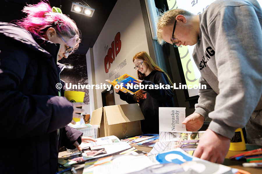 Dakota Harris, center, junior Psychology major, looks through a magazine for pictures to make into a