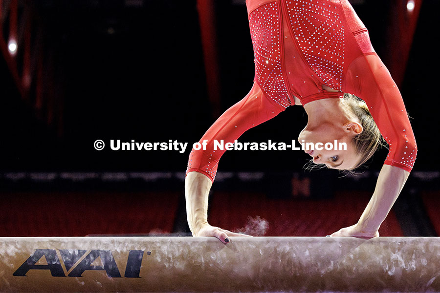 Emma Spence begins her dismount from the balance beam during their gymnastics meet against Michigan 