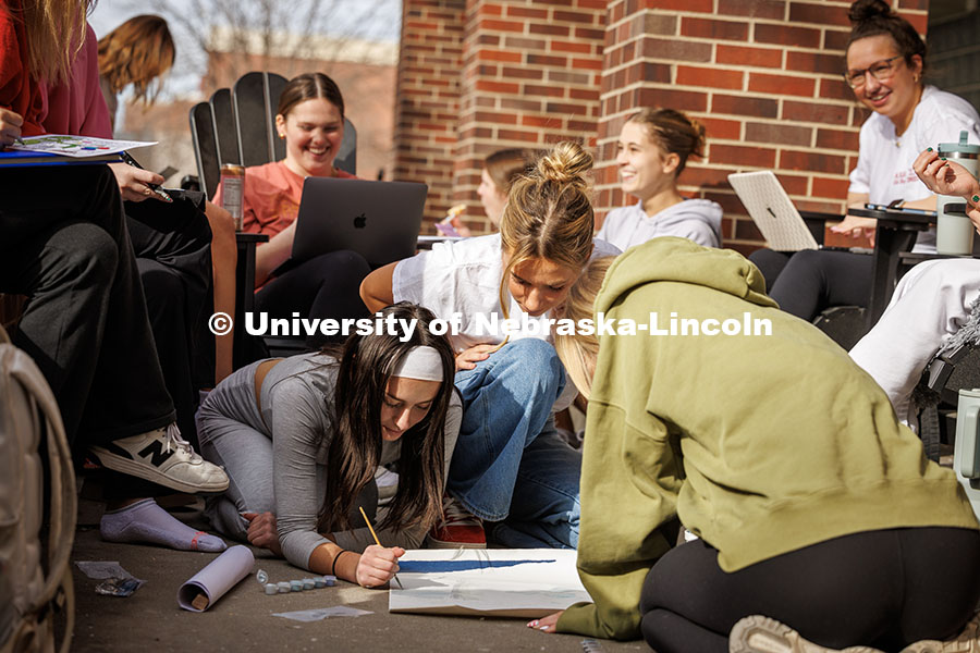 Alpha Chi Omega sisters sit in front of their house together enjoying the warm winter weather. Febru