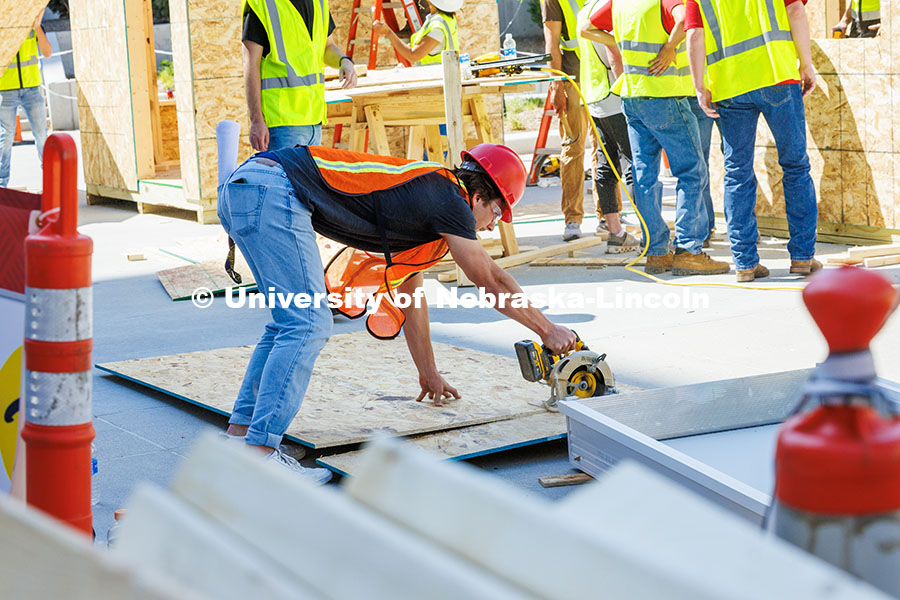 250508_Const_Mgmt_219.jpg Nick Loibl, a junior Construction Management major, saws into a plank of wood during shed building d