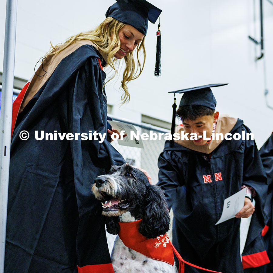 250516_Grad_Commencement_0064.jpg (Left) Accountancy graduate students, Mallory Schuh and Alvan Tran, pet Cash, the University Police