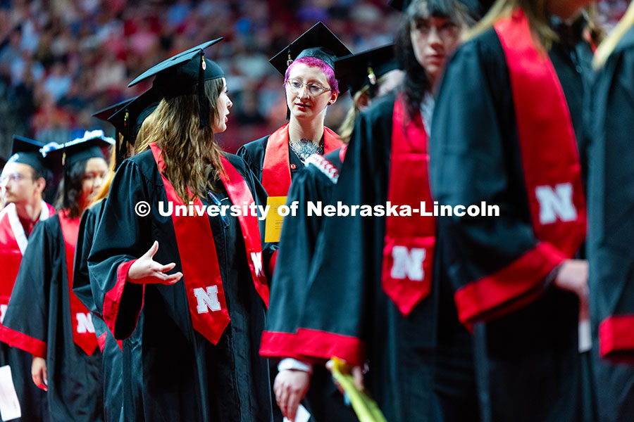 250517_Commencement_1518.jpg Graduates chat in line during the morning commencement ceremony processional into Pinnacle Bank Aren