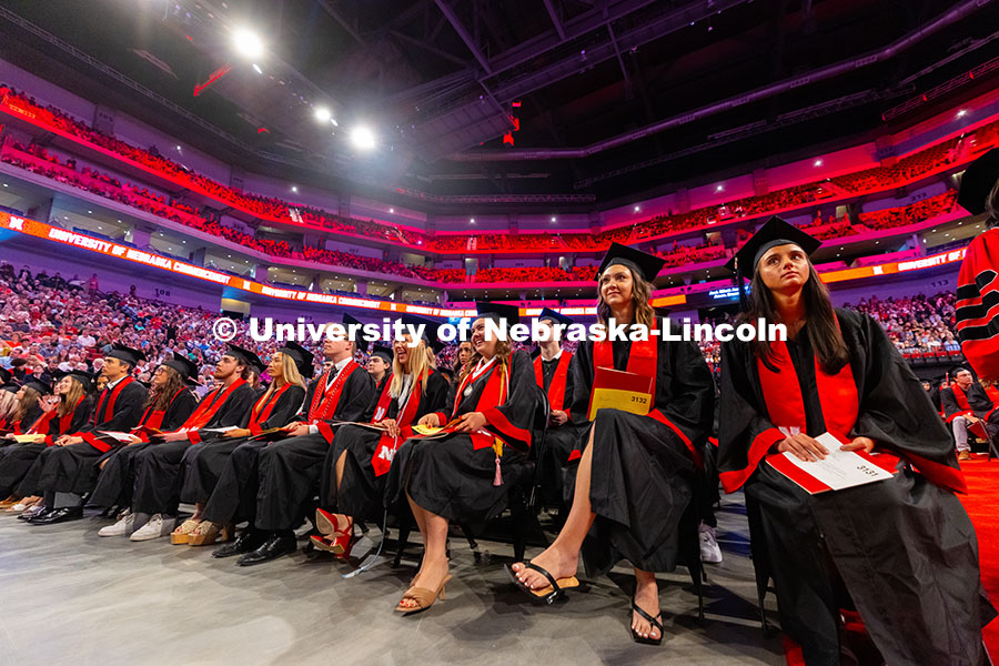 250517_Commencement_7859.jpg College of Journalism and Mass Communications graduates laugh as they wait to receive their diplomas
