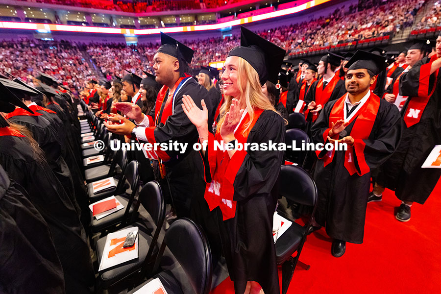 Business Administration graduate Emily Nau claps at the end of the University of Nebraska–Lincoln'