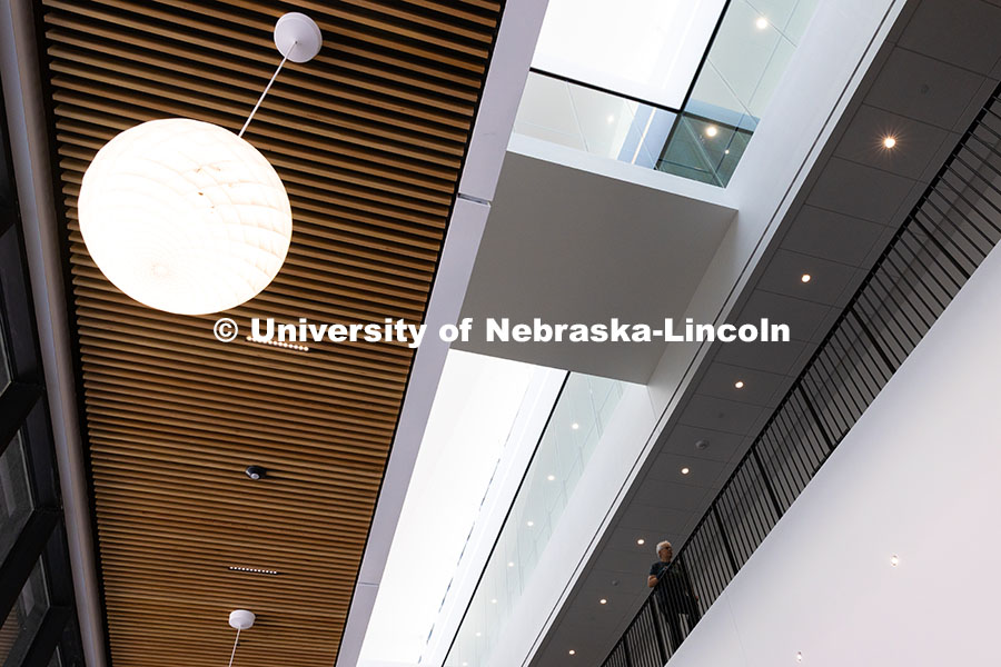 250522_FPA_8757.jpg A faculty member walks along the second-floor railing in the new Hixson-Lied College of Fine and Per
