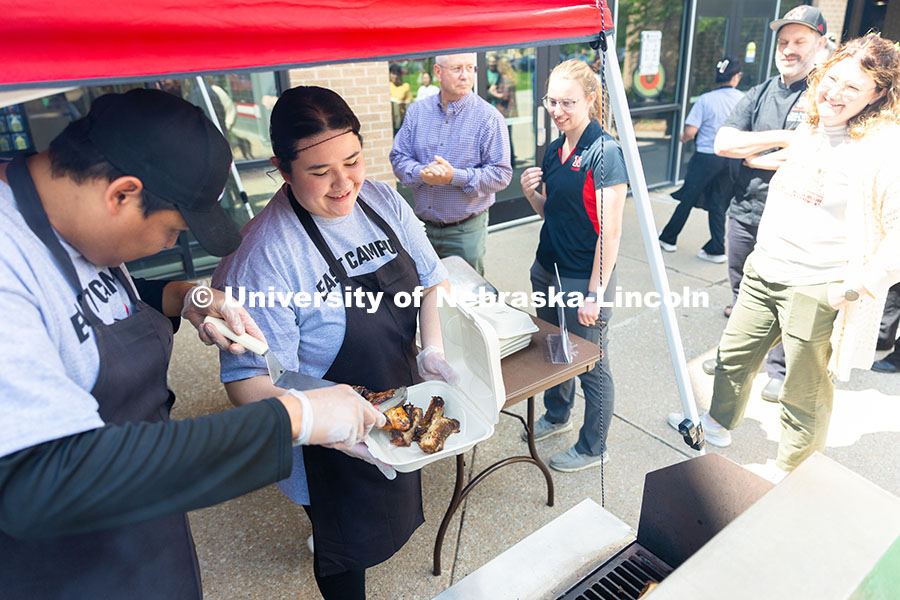 250529_Grill_Out_9384.jpg Aubrey Wyatt holds a to-go container open as Franklin Yankton fills a customer's order for chicken a