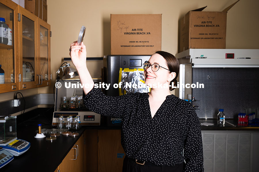 250618_Erin_Carr_532.jpg Erin Carr, a postdoctoral research associate, holds up a petri dish filled with streaky, spotty blac