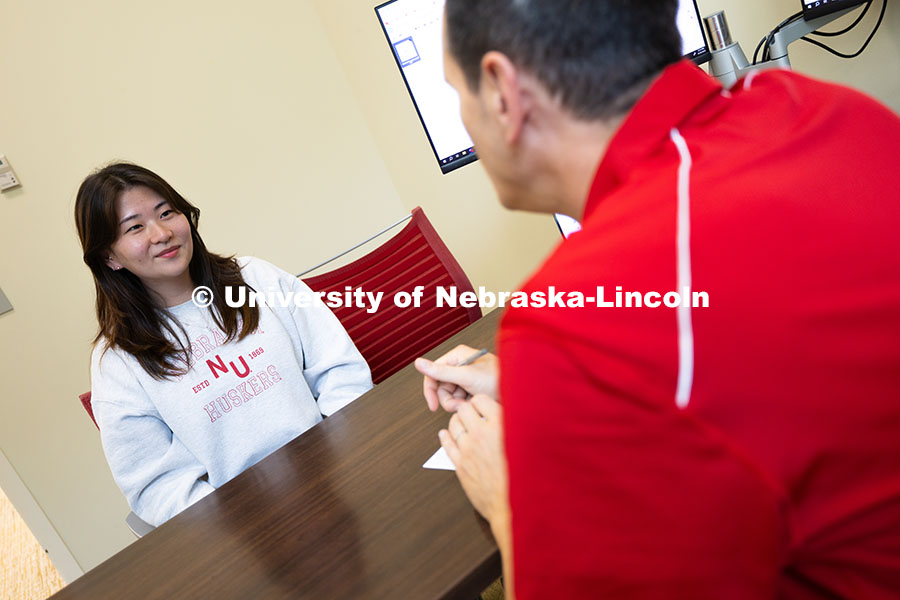 Parker Reed speaks with Mireu Ryu, a senior studying computer science, in his office in Hawks Hall. 