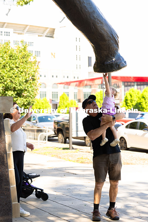 250709_City_Campus_2556.jpg Greg Ferderer lifts his two-year-old granddaughter, Lexi, up to Archie, the bronze mammoth statue in