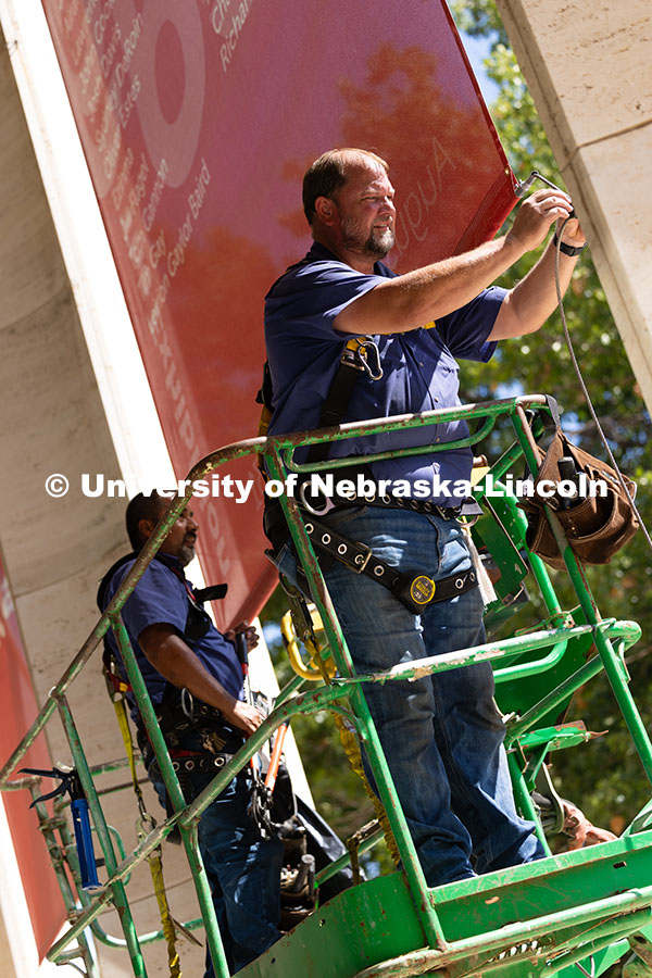 Justin DeBoer (right) and Geraldo Martinez (left), both exteriors technicians at UNL, adjust the cab