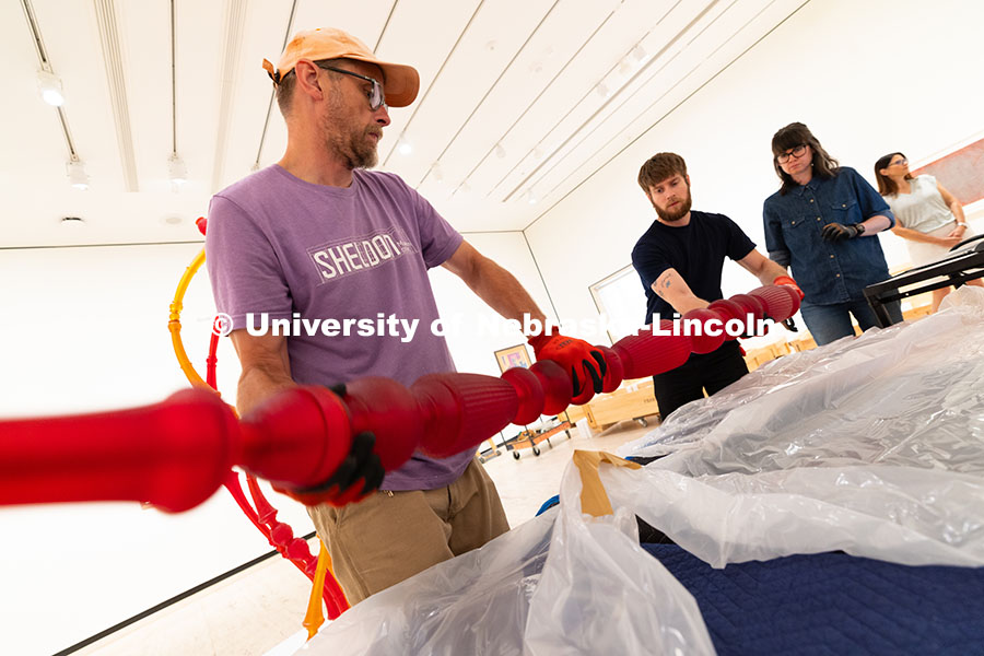 Delan Lonowski (left) and Quentin Fortney (right), on-call exhibition technicians, move part of a sc