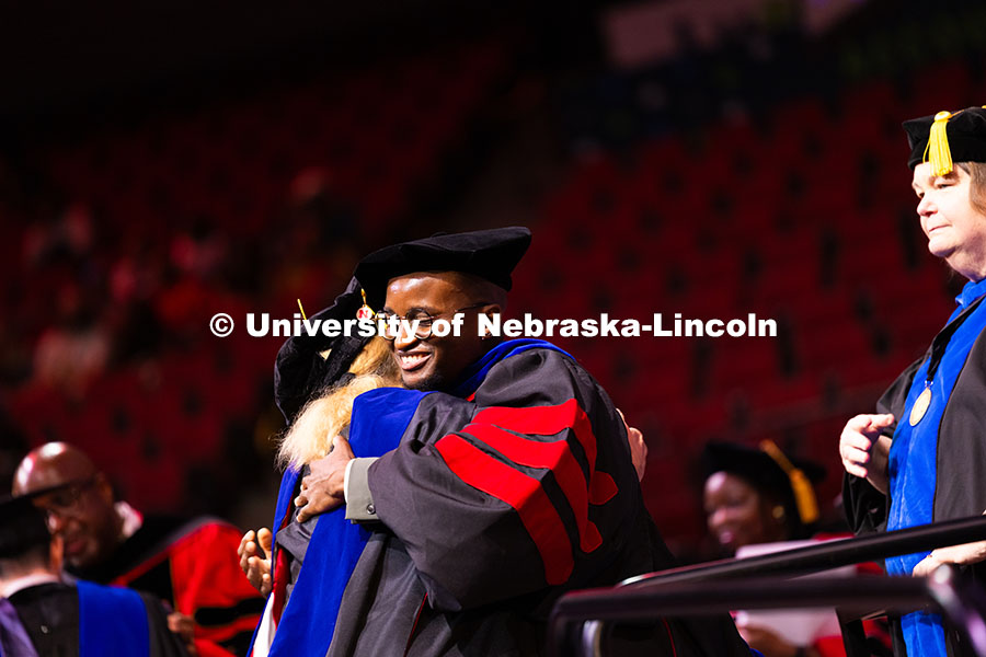 Esihle Lupindo hugs Professor Lisa Kort-Butler after being hooded. Lupindo received his doctorate in