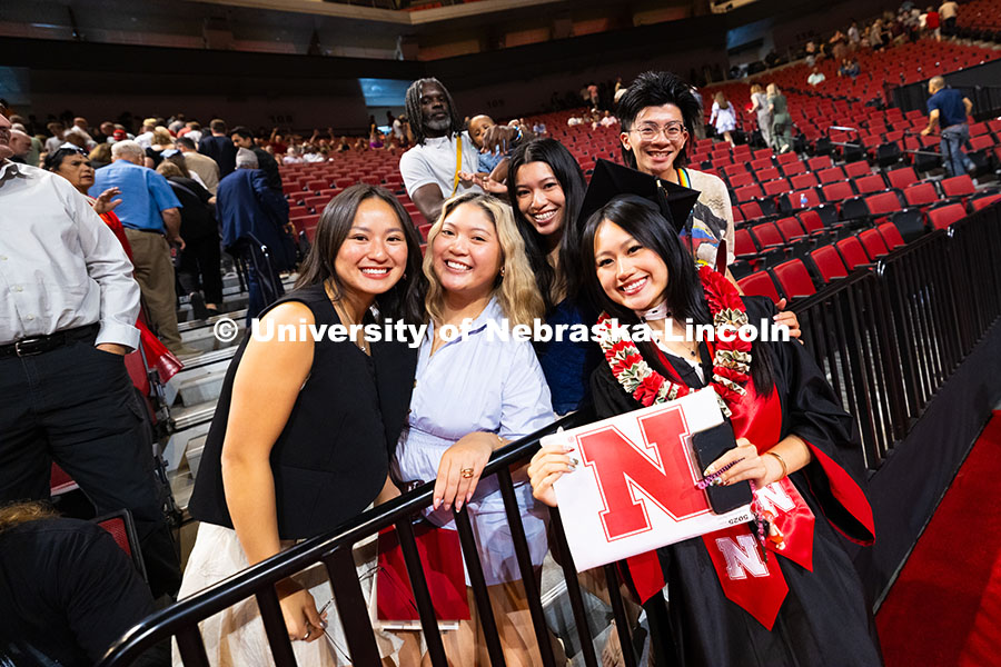 Elizabeth Nguyen poses for a photo with family and friends after receiving her bachelor's degree at 