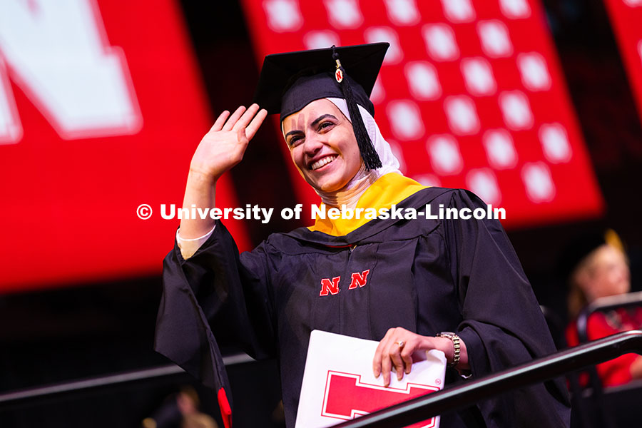 Amasi Ali Hassan Hajahja waves toward family and friends after receiving her master's degree during 