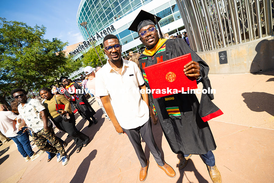Dela Gohoho holds up his degree outside of Pinnacle Bank Arena. He received his master's in chemical