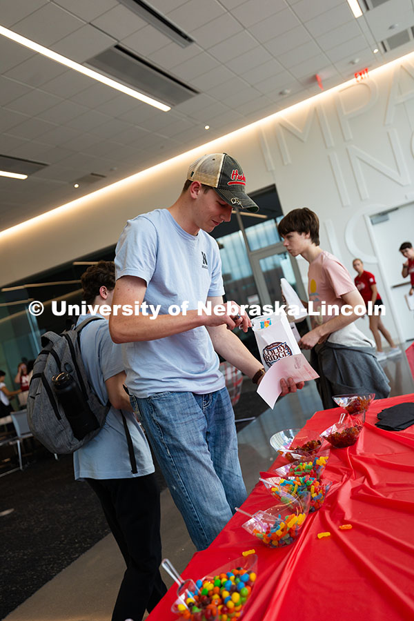 Ethan Zelasney adds gummy worms to a bag of popcorn during the College of Engineering welcome progra