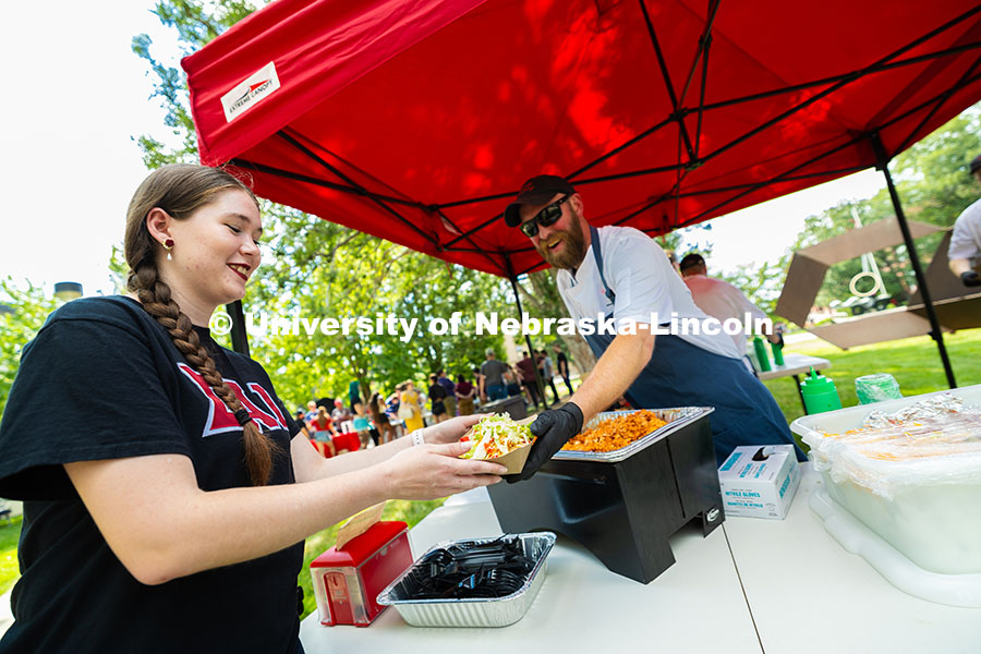 250821_Welcome_Parties_4117.jpg Abbie Taber, a senior studying flute performance, gets a bowl of nachos from Jake Dietrich during th
