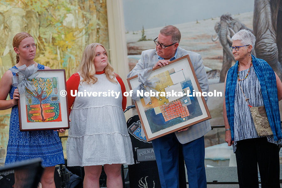 250821_Zeleny_Farewell_343.jpg Mike Zeleny and his girls hold up pieces of art given as a farewell gift. Also pictured is the artis
