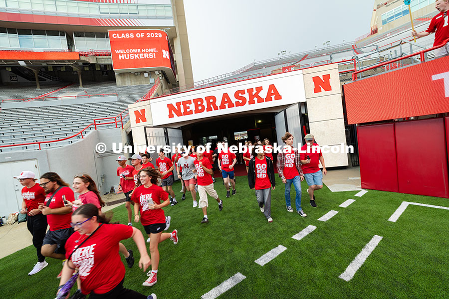 Students run onto the field during the Tunnel Walk into Memorial Stadium. The Tunnel Walk is for inc