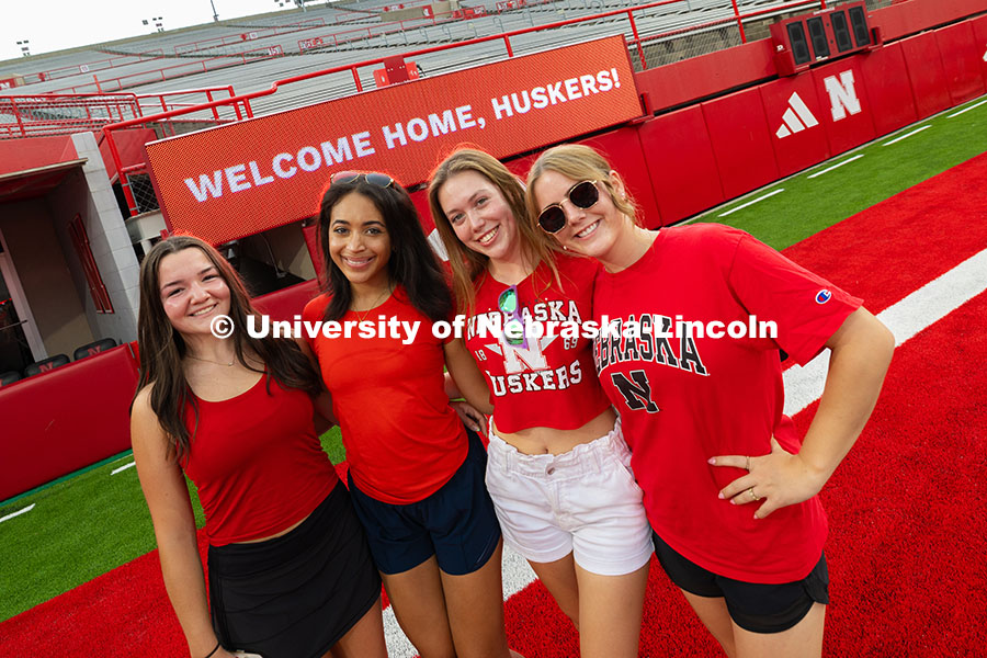 Students pose in front of a sign that says, "Welcome Home, Huskers!" during the Tunnel Walk into Mem