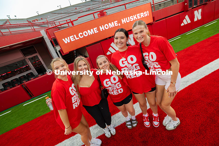 Students pose in front of a sign that says, "Welcome Home, Huskers!" during the Tunnel Walk into Mem