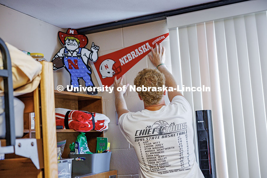 250819_Move_In_030.jpg AJ Arensberg, a Sports Media and Communication major, puts up a Nebraska flag in his dorm in Abel Ha