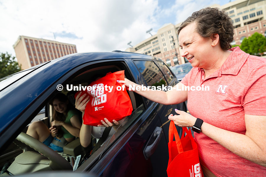 Dee Dee Anderson, Vice Chancellor for Student Life, hands swag bags to Jessica Longacre and her room