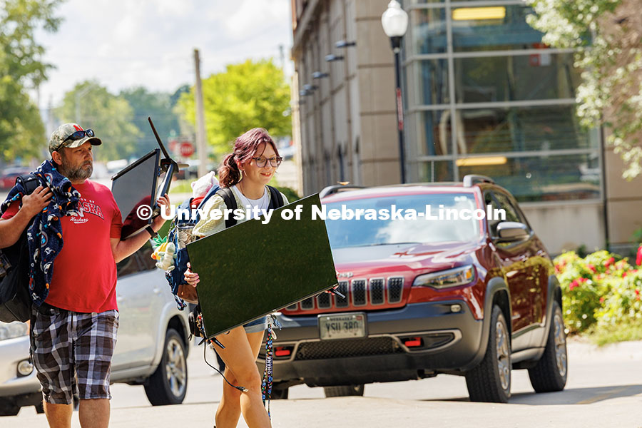 250820_Move_In_552.jpg Sophia Bartlett carries a TV into University Suites during move-in day. Residence hall move-in. Augu