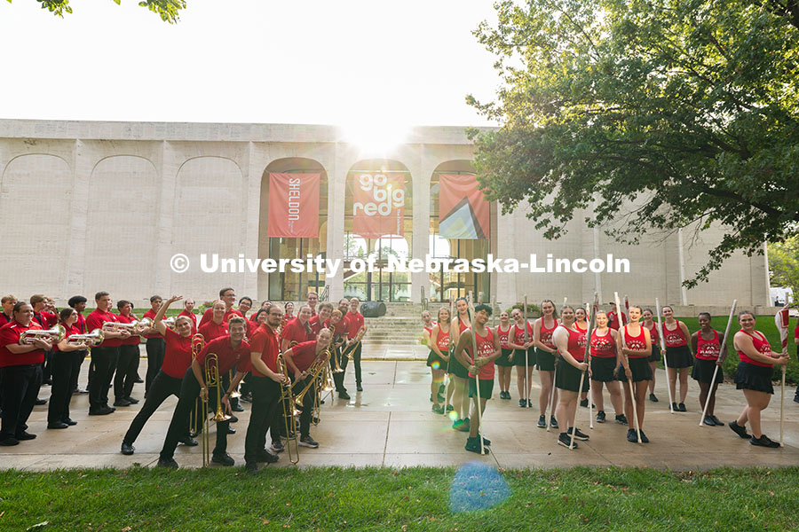 Members of the marching band pose outside of the Sheldon Museum of Art as they line up to march to M