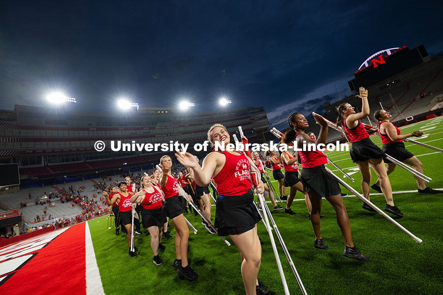 Color guard members dance out of Memorial Stadium after the band exhibition. Cornhusker Marching Ban