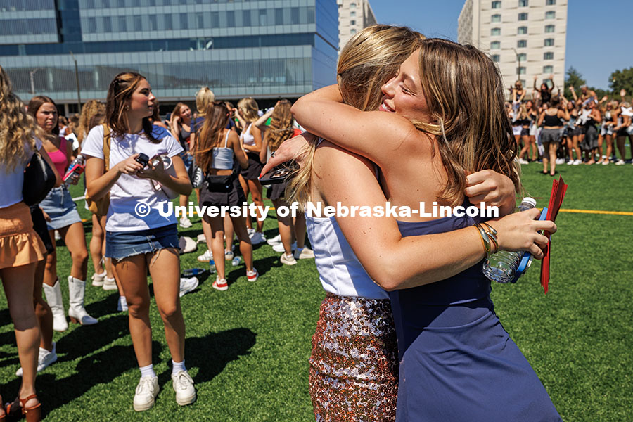 A potential new member and a sorority member hug each other as the other potential new members arriv